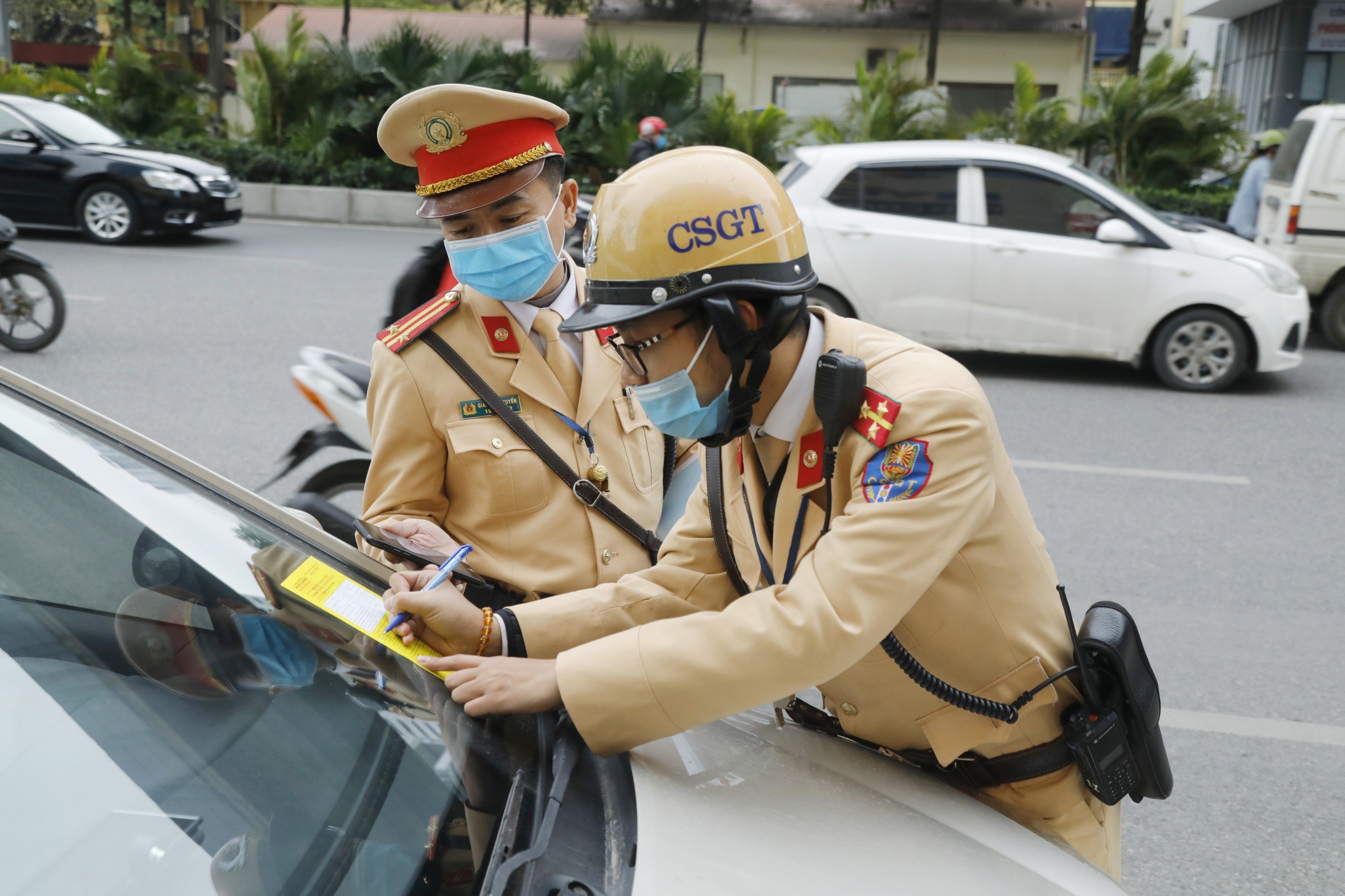 Cảnh sát giao thông tiến hành dán thông báo xử phạt nguội lên kính xe